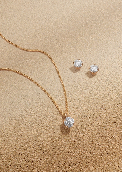 Goldsmiths Signature Diamond Yellow Gold Jewellery on sandy background image